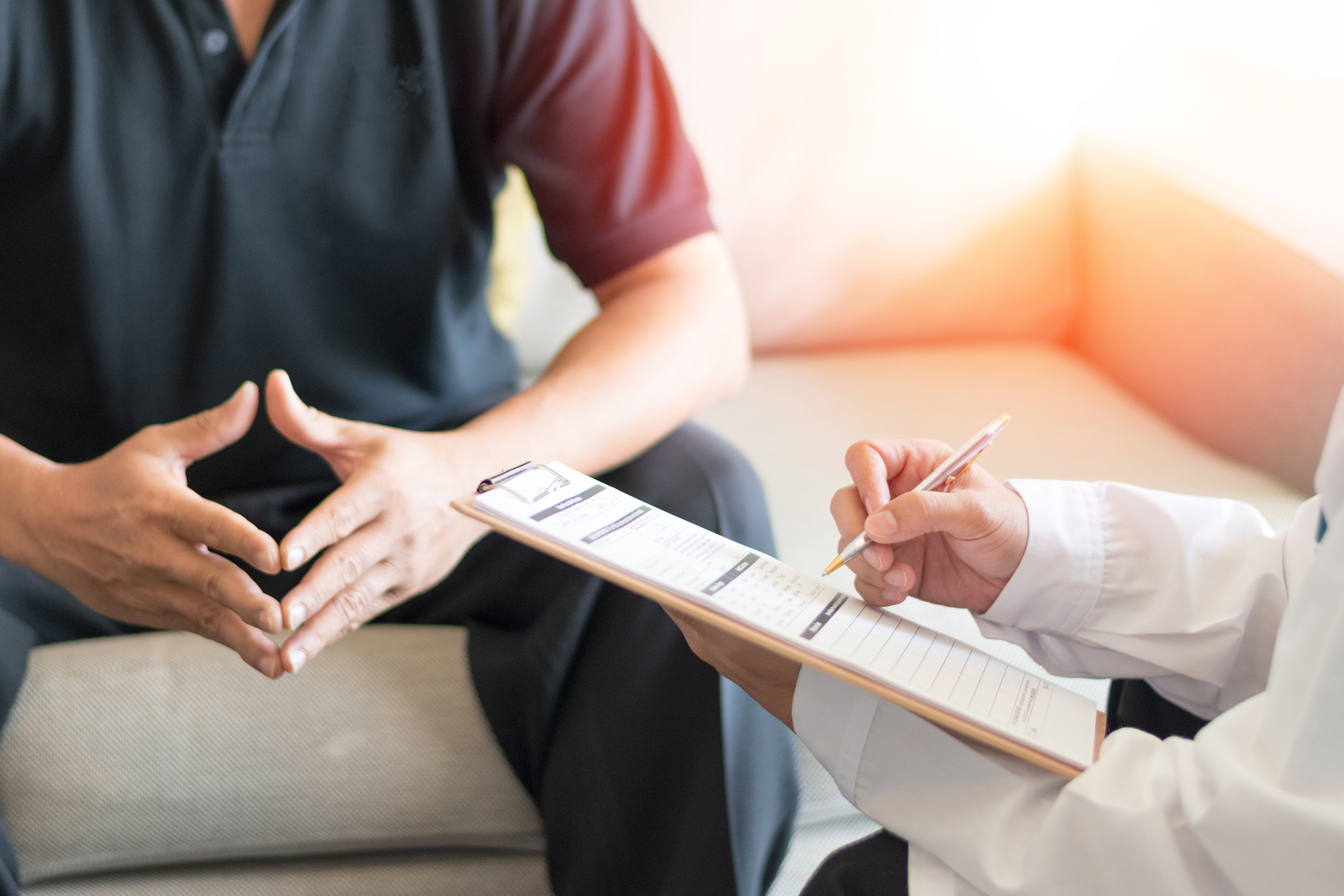 person on couch being interviewed by doctor with clipboard