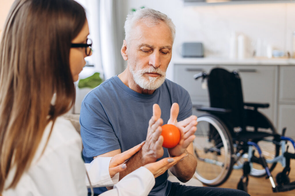 Senior man receiving physical therapy for hand rehabilitation